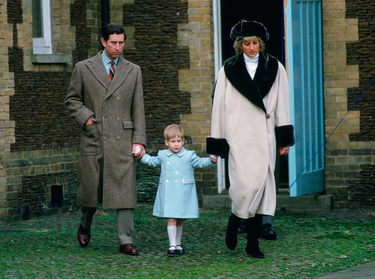 Then-Prince Charles and Princess Diana holding Prince Harry's hands as they arrive at Sandringham