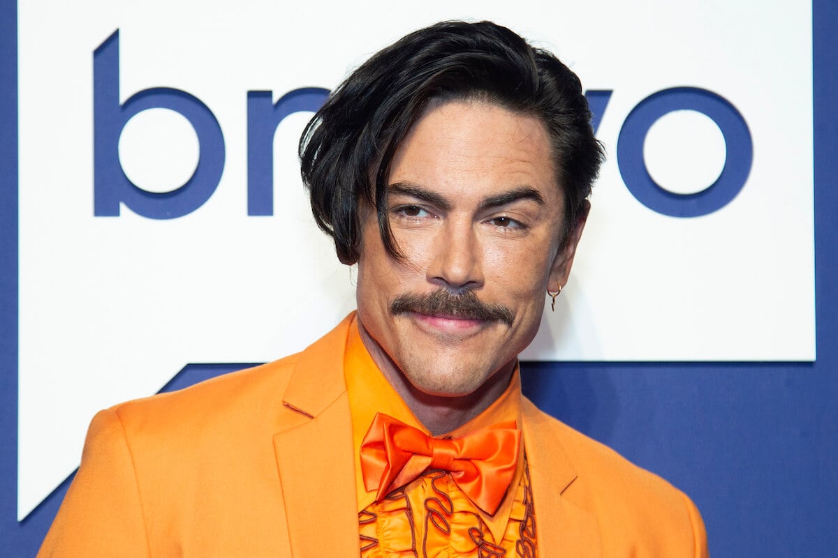 "Vanderpump Rules" star Tom Sandoval smiles and poses at an event.
