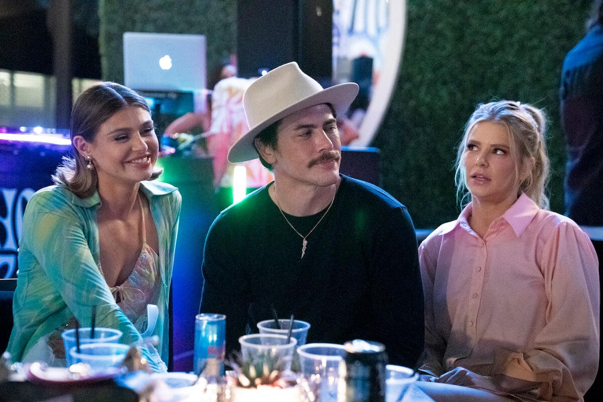 'Vanderpump Rules' homewreckers Tom Sandoval and Raquel Leviss sit next to Ariana Madix at a table in a production still from season 10.