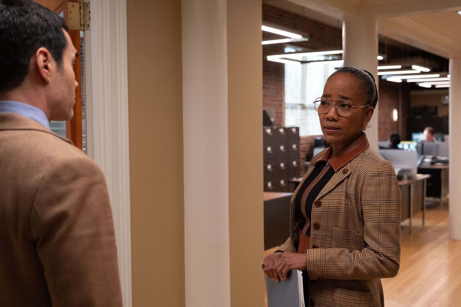 Sonja Sohn, in character as Amanda Wagner in 'Will Trent' Season 1 Episode 10, wears a tan plaid coat over a black and brown collared sweater.
