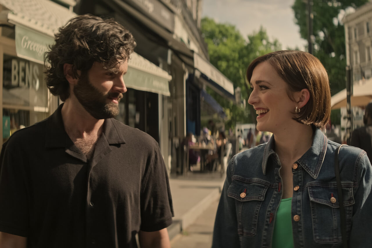Joe Goldberg (Penn Badgley) and Kate (Charlotte Ritchie) walk on a sidewalk and look at each other in 'You'.