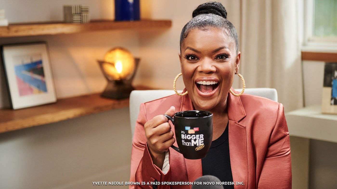 Yvette Nicole Brown smiles with a coffee cup 