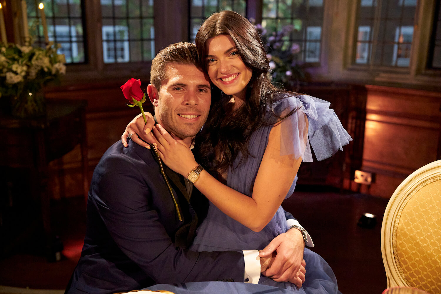 'The Bachelor' Season 27 finale runner-up Gabi Elnicki sitting on Zach Shallcross's lap while smiling and holding a rose