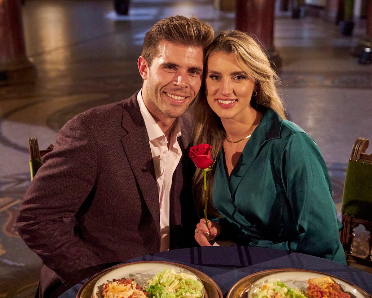 'The Bachelor' Season 27 finale winner Kaity Biggar sitting next to Zach Shallcross at dinner while smiling and holding a rose