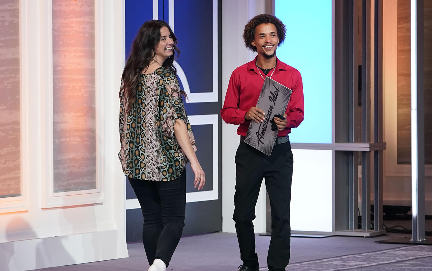 American Idol 2023 platinum ticket winner Cam Amen walks backward while holding his ticket as his girlfriend walks beside him