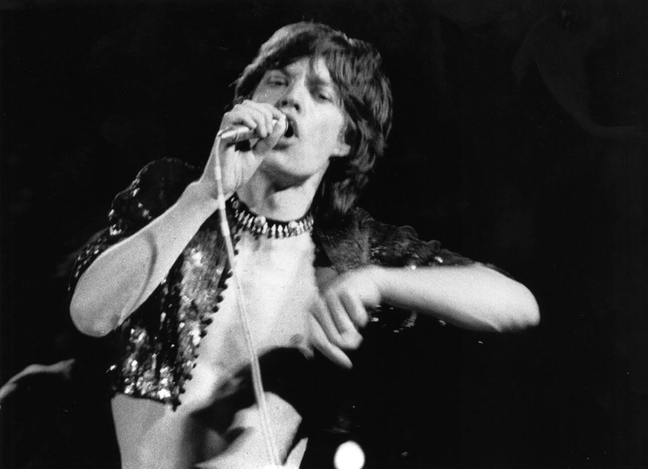 A black and white picture of Mick Jagger singing into a microphone. 