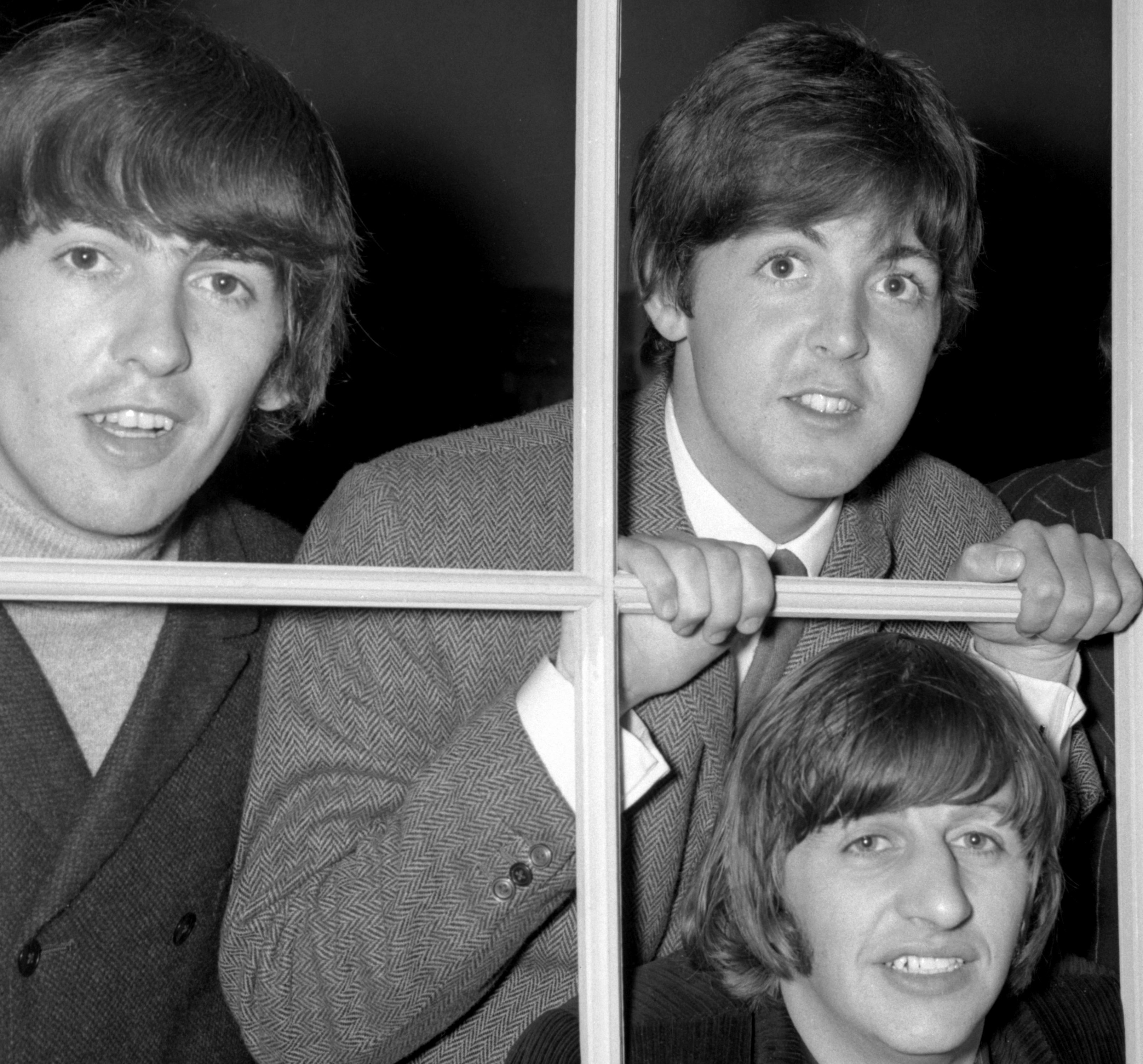 The Beatles near a window