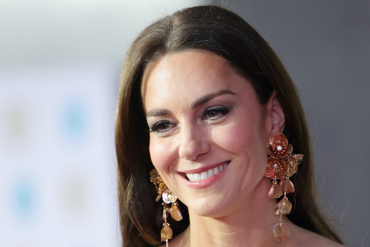 Kate Middleton smiles at the 2023 BAFTAs wearing natural makeup including subtle lipstick