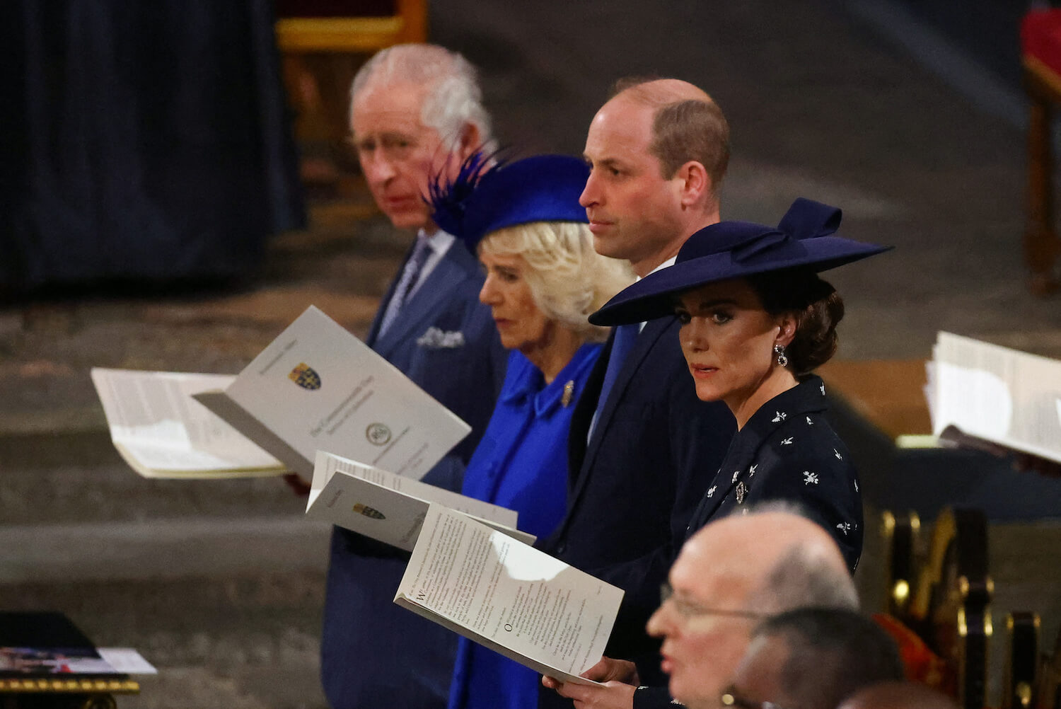 Kate Middleton wears a hat and looks to the side during commonwealth day service as she stands beside royal family