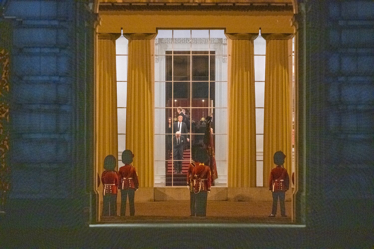 King Charles, Prince Harry, and Meghan Markle seen through a window at Buckingham Palace before queen's funeral