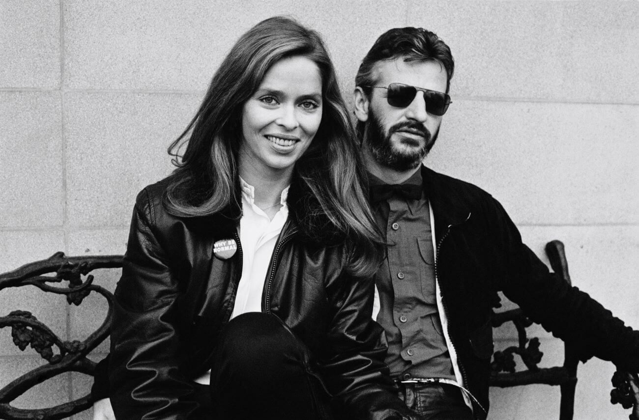 A black and white picture of Barbara Bach and Ringo Starr sitting on a bench. The musician married the actor in 1981.