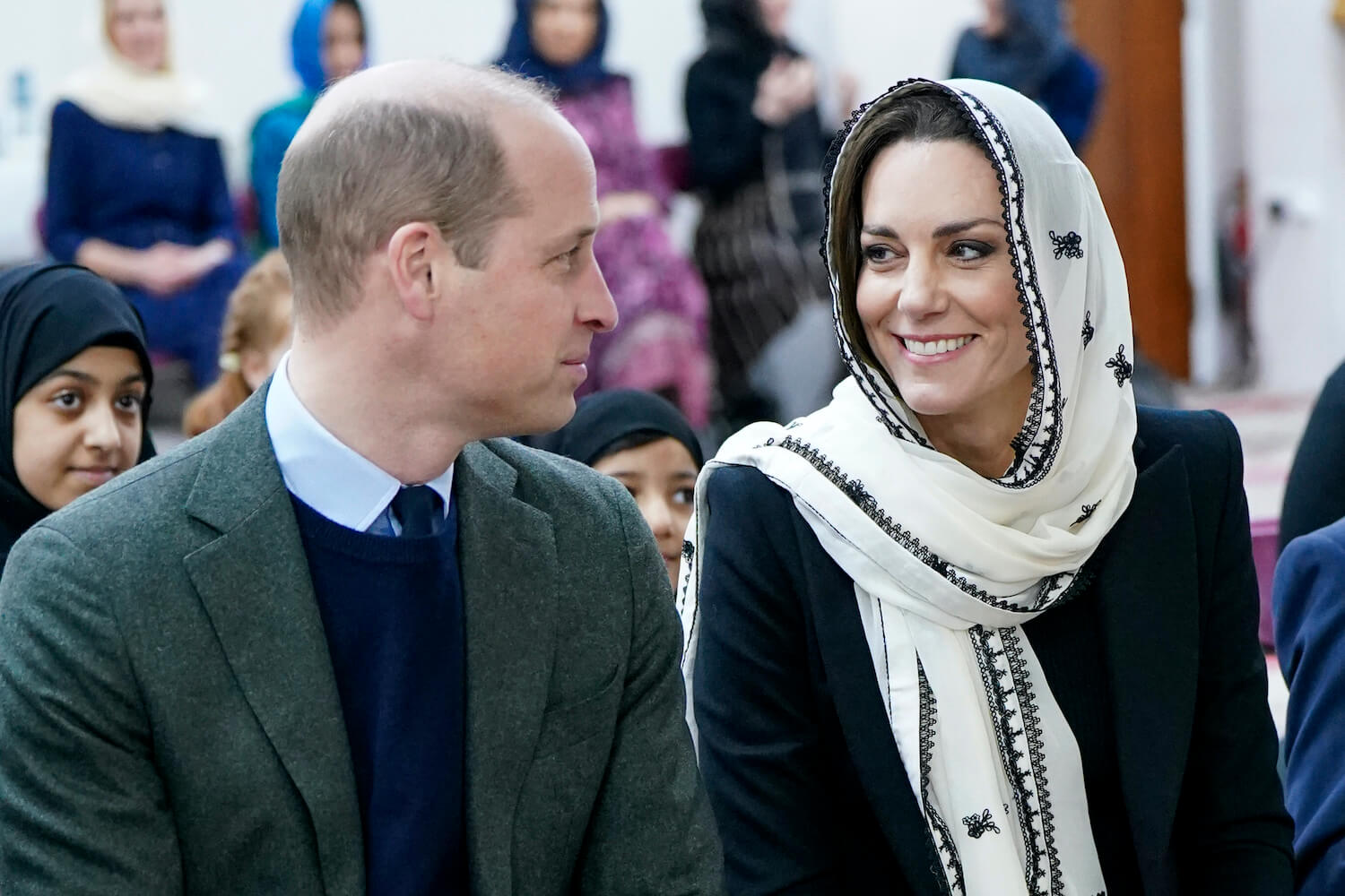 Prince William and Kate Middleton show intense body language with William making eye contact with Kate, who smiles while wearing a head scarf