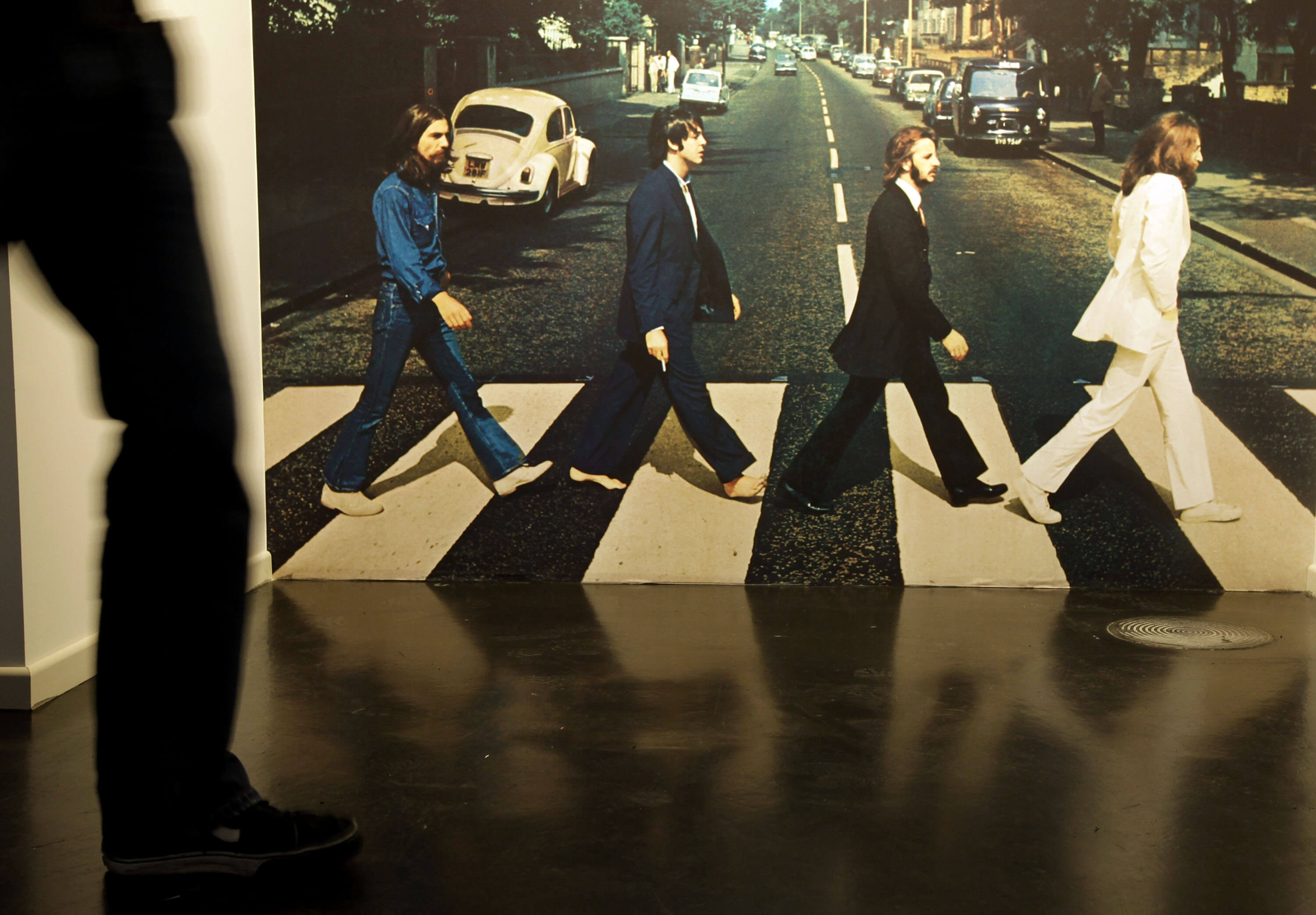 Someone near an image of the cover of The Beatles' 'Abbey Road'