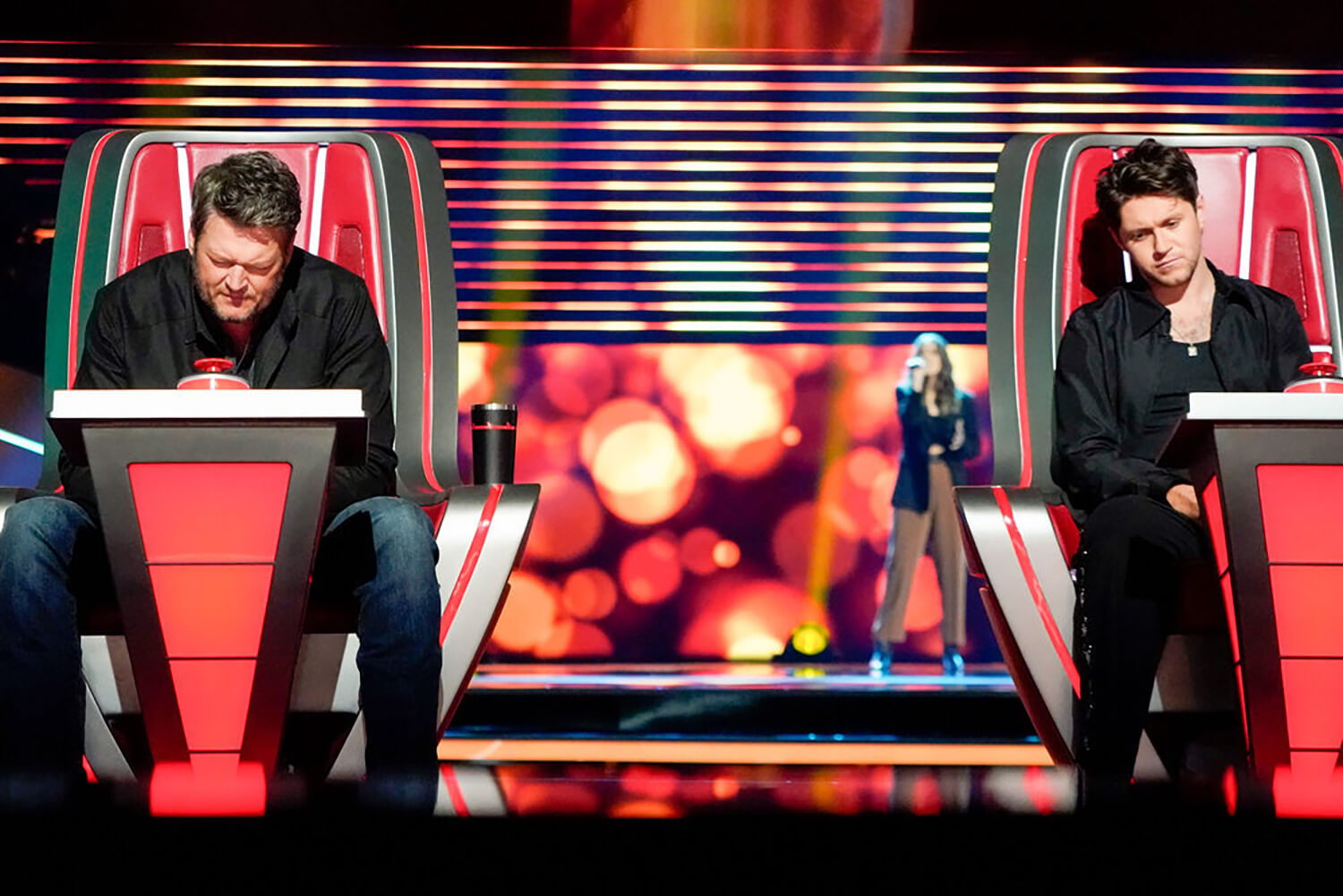 Blake Shelton and NIall Horan concentrate as they listen to a contestant's audition on The Voice Season 23.