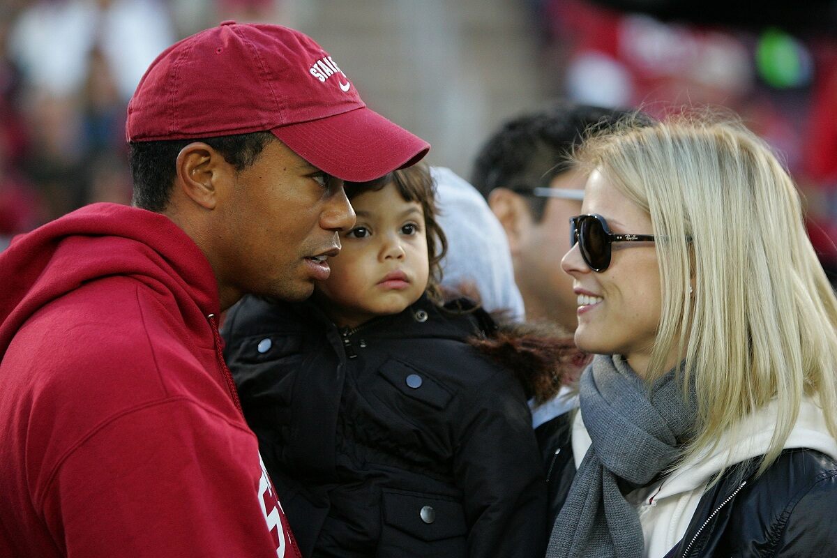 Tiger Woods and one of his exes, Elin Nordegren. Woods is outfited in a Stanford hat and sweatshirt while holding their daughter, Sam.