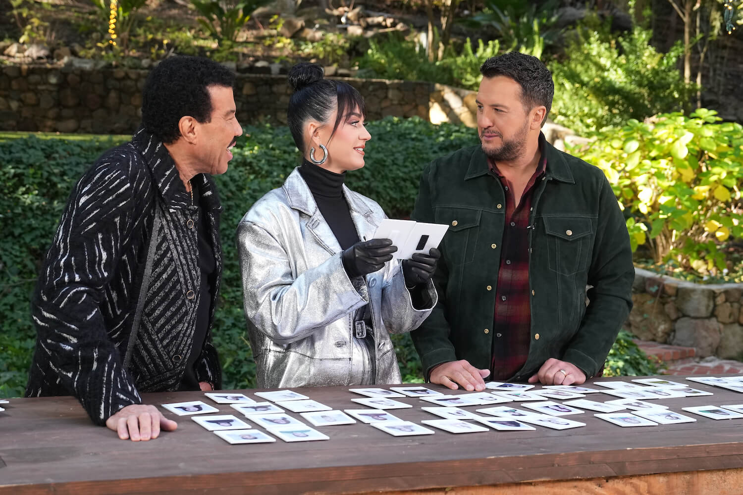 Lionel Richie, Katy Perry, and Luke Bryan talking about theh 'American Idol' 2023 cast while outside with photos