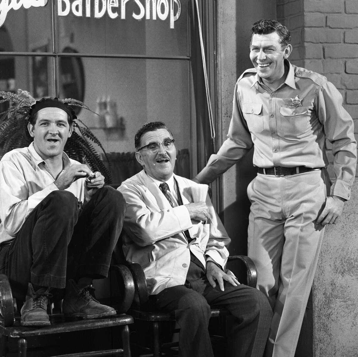Goober Pyle, Floyd Lawson and Andy Taylor sit together outside of the barber shop in an episode of 'The Andy Griffith Show' Goober was given a spinoff that ultimately failed after just one episode.