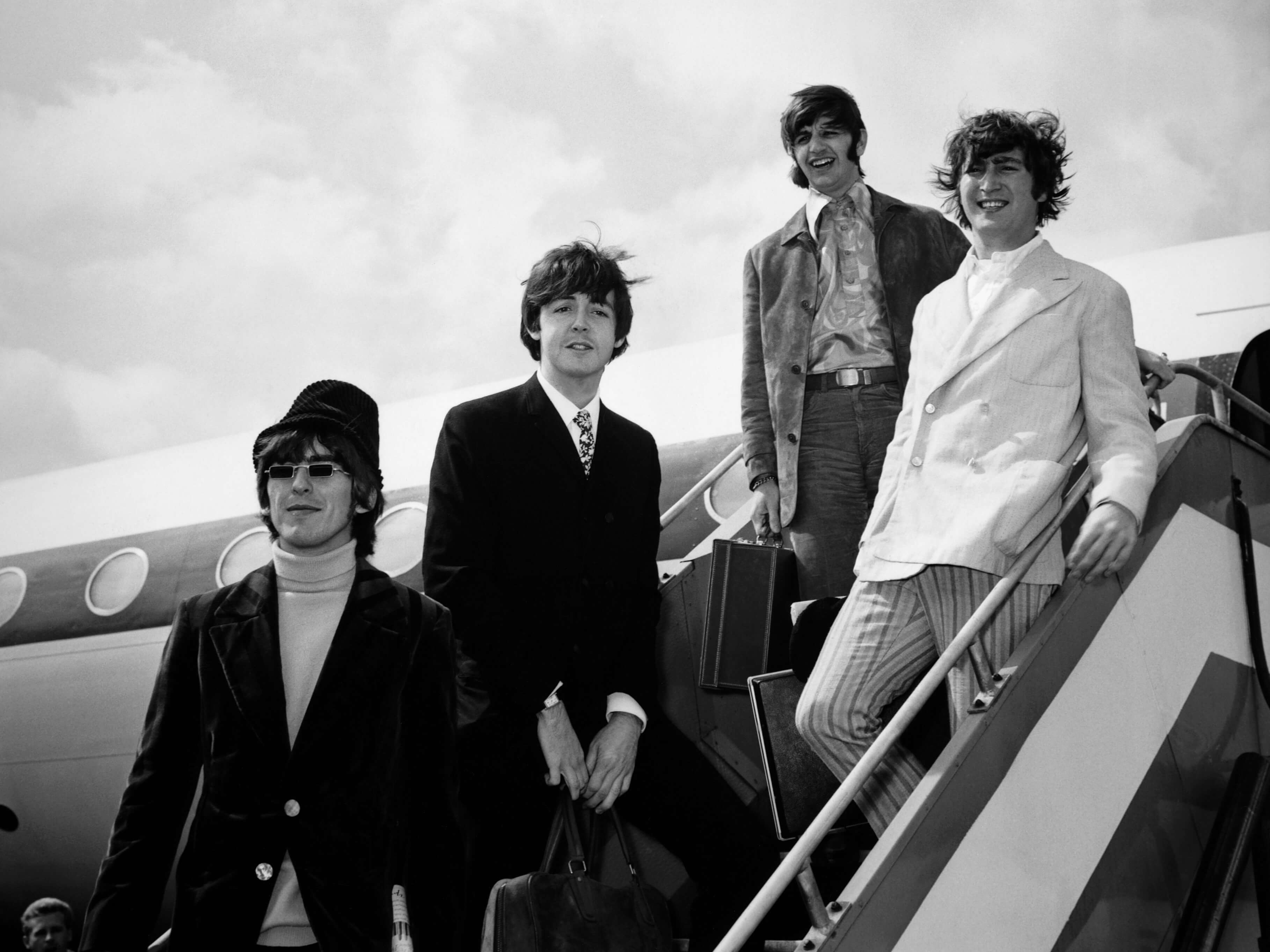 Beatles members (from left) George Harrison, Paul McCartney, Ringo Starr, and John Lennon walk off an airplane in 1966.