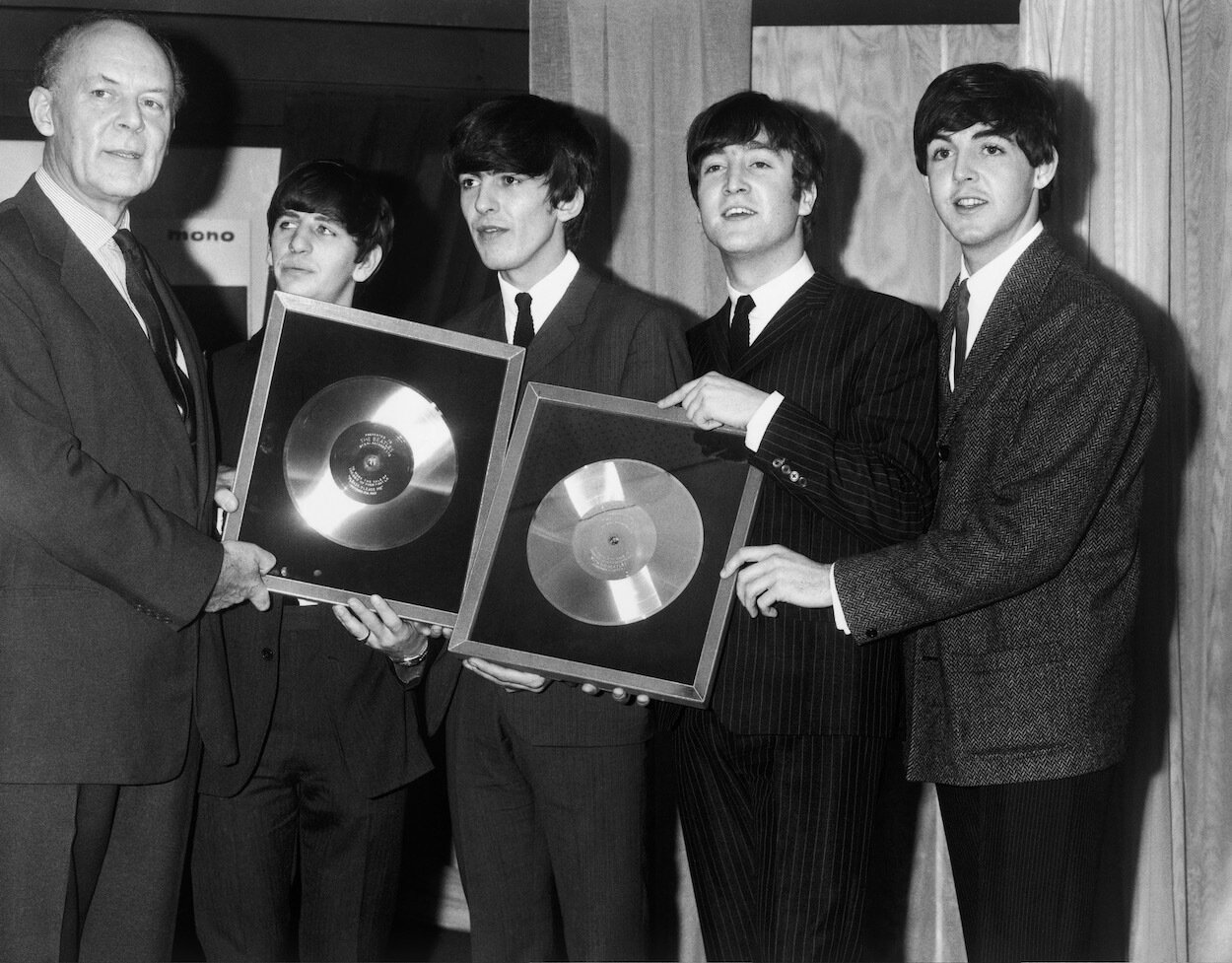 EMI Records chairman Joseph Lockwood presents Ringo Starr, George Harrison, John Lennon, and Paul McCartney with silver records in 1963 for the first two LPs.