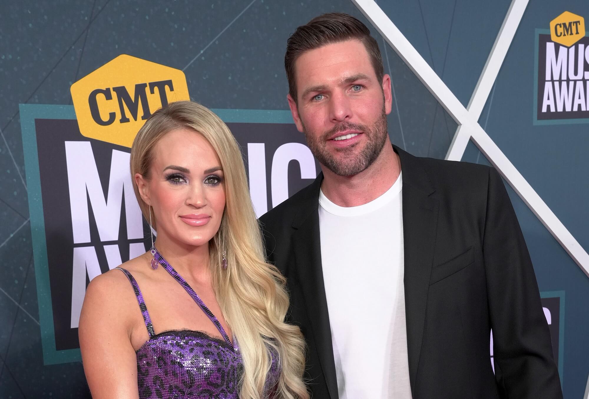 Carrie Underwood and Mike Fisher look into the camera while standing side by side
