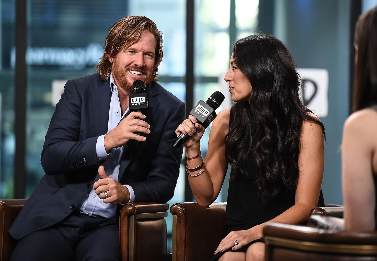 'Fixer Upper' stars Chip and Joanna Gaines speaking into microphones while sitting next to each other