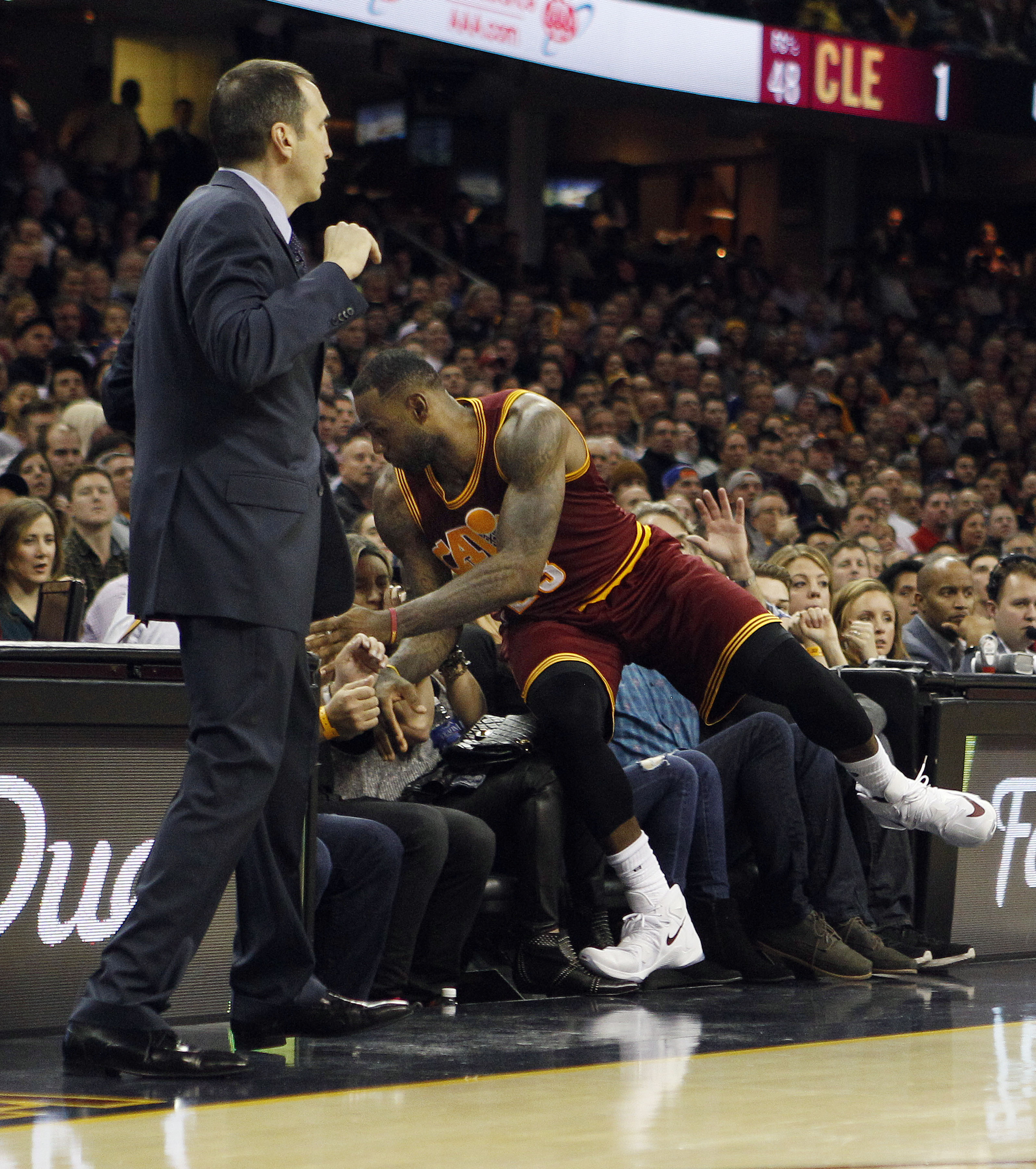 Cleveland Cavaliers goes into the stands after a loose ball and crashes into Jason Day's wife