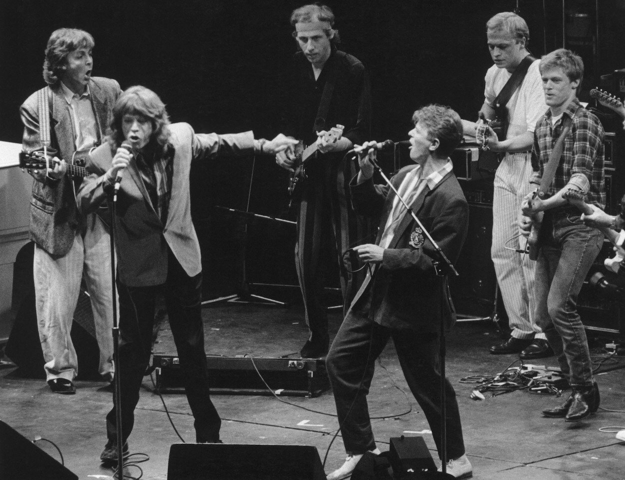 Beatles bassist Paul McCartney (from left), Rolling Stones singer Mick Jagger, Dire Straits guitarist Mark Knopfler, and David Bowie, among others, perform at the Prince's Trust Concert in 1986.