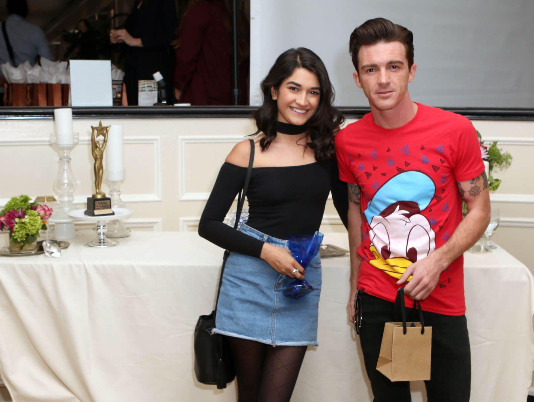 Drake Bell and wife Janet Von Schmeling standing next to each other and smiling. Drake Bell and his wife have one kid together.
