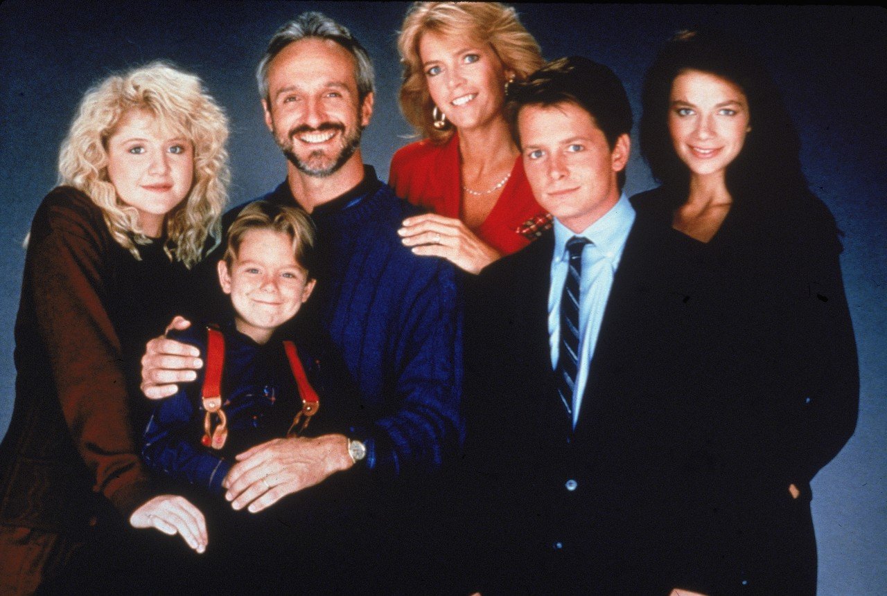 The Family Ties cast poses together.