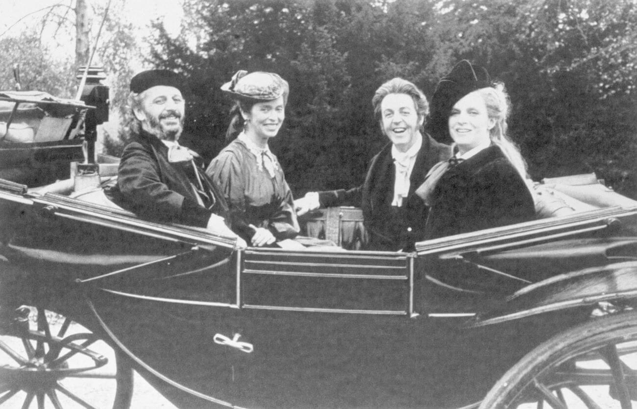 A black and white picture of Ringo Starr, Barbara Bach, Paul McCartney, and Linda McCartney in a carriage on the set of 'Give My Regards to Broad Street.'