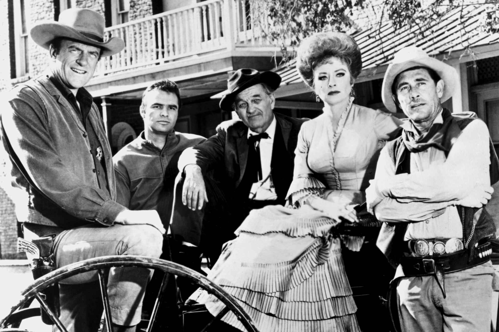 'Gunsmoke' James Arness as Matt Dillon, Burt Reynolds as Quint Asper, Milburn Stone as Doc Adams, Amanda Blake as Miss Kitty Russell, and Ken Curtis as Festus Haggen in a black-and-white picture sitting on a carriage.