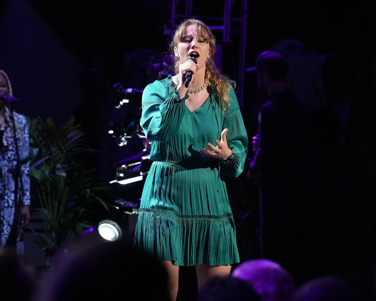 Hannah Nicolaisen in the 'American Idol' 2023 top 26 singing on stage while wearing a green dress