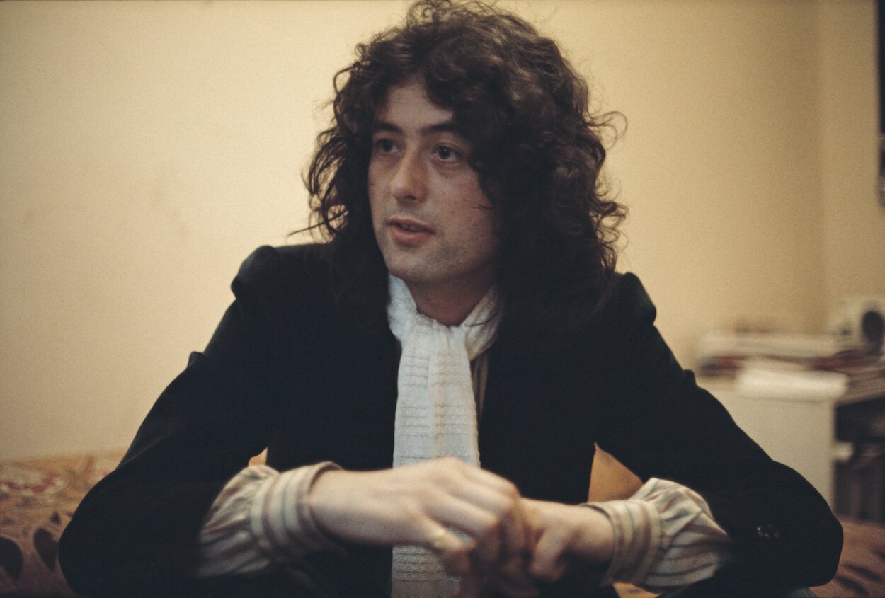 Led Zeppelin guitarist Jimmy Page wears a black shirt and white scarf during a 1976 interview.
