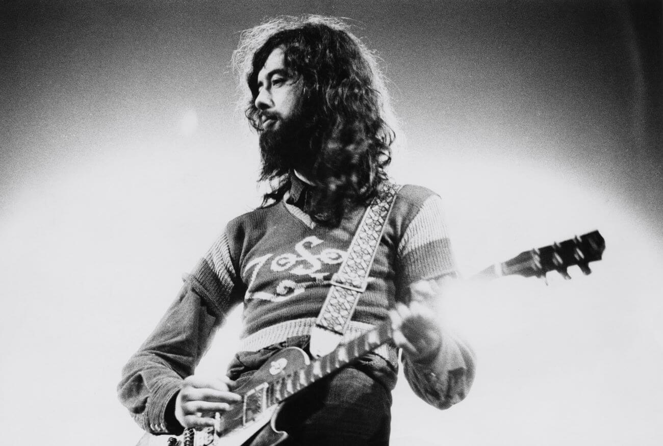 A black and white picture of Jimmy Page playing guitar. 