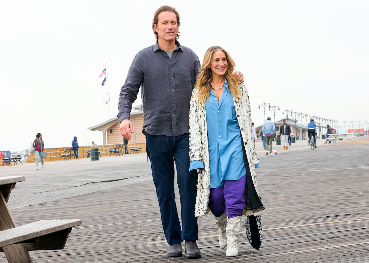 John Corbett with his arm around Sarah Jessica Parker while they walk together