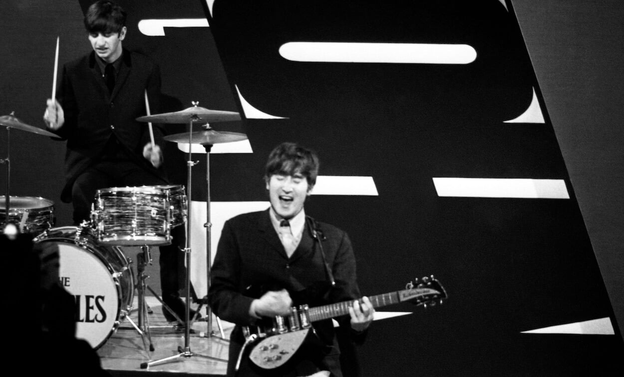 Ringo Starr (left) drums in the background while John Lennon sings and plays guitar during a Beatles TV appearance in December 1963.
