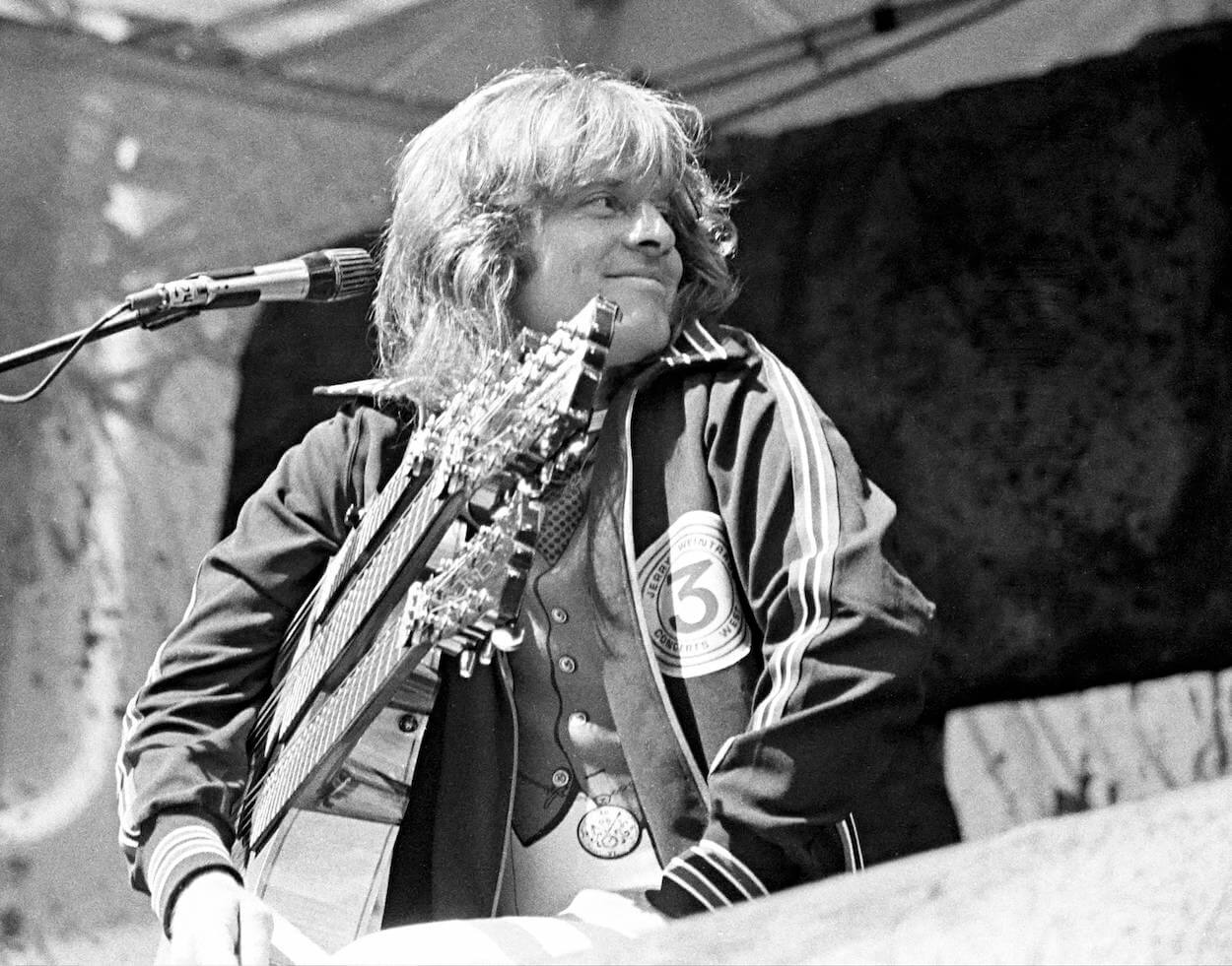 Led Zeppelin's John Paul Jones smiles while look over his shoulder during a 1977 concert in Oakland, California.