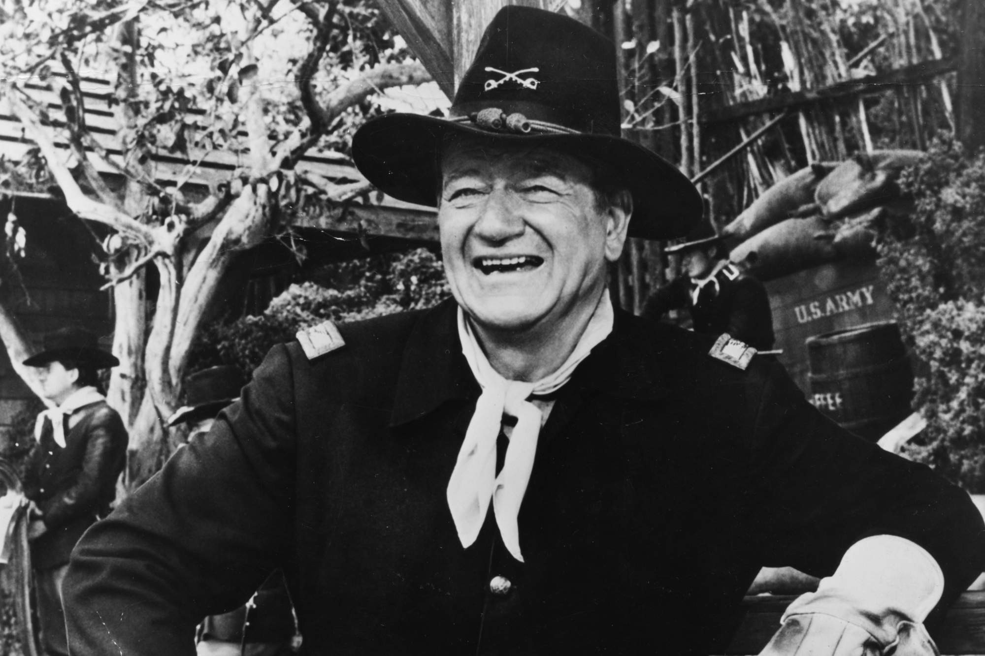 John Wayne with a strong public image. He's smiling, wearing a Western costume for 'Rio Lobo.'