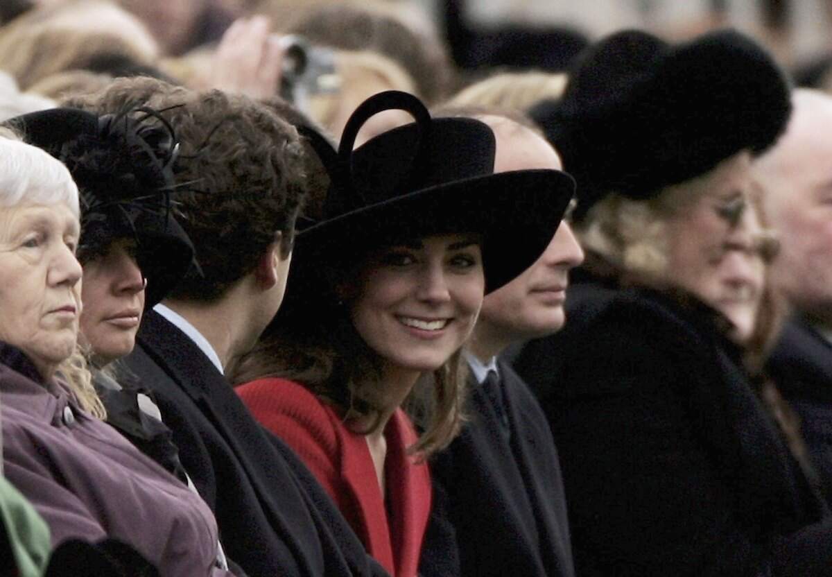 Wearing a black hat, Kate Middleton looks around while watching William take part in The Sovereign's Parade in 2006