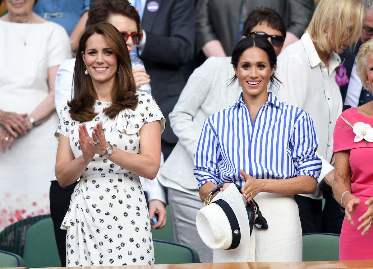 Kate Middleton and Meghan Markle, who are 'inverted versions of each other, according to a historian, smile and clap