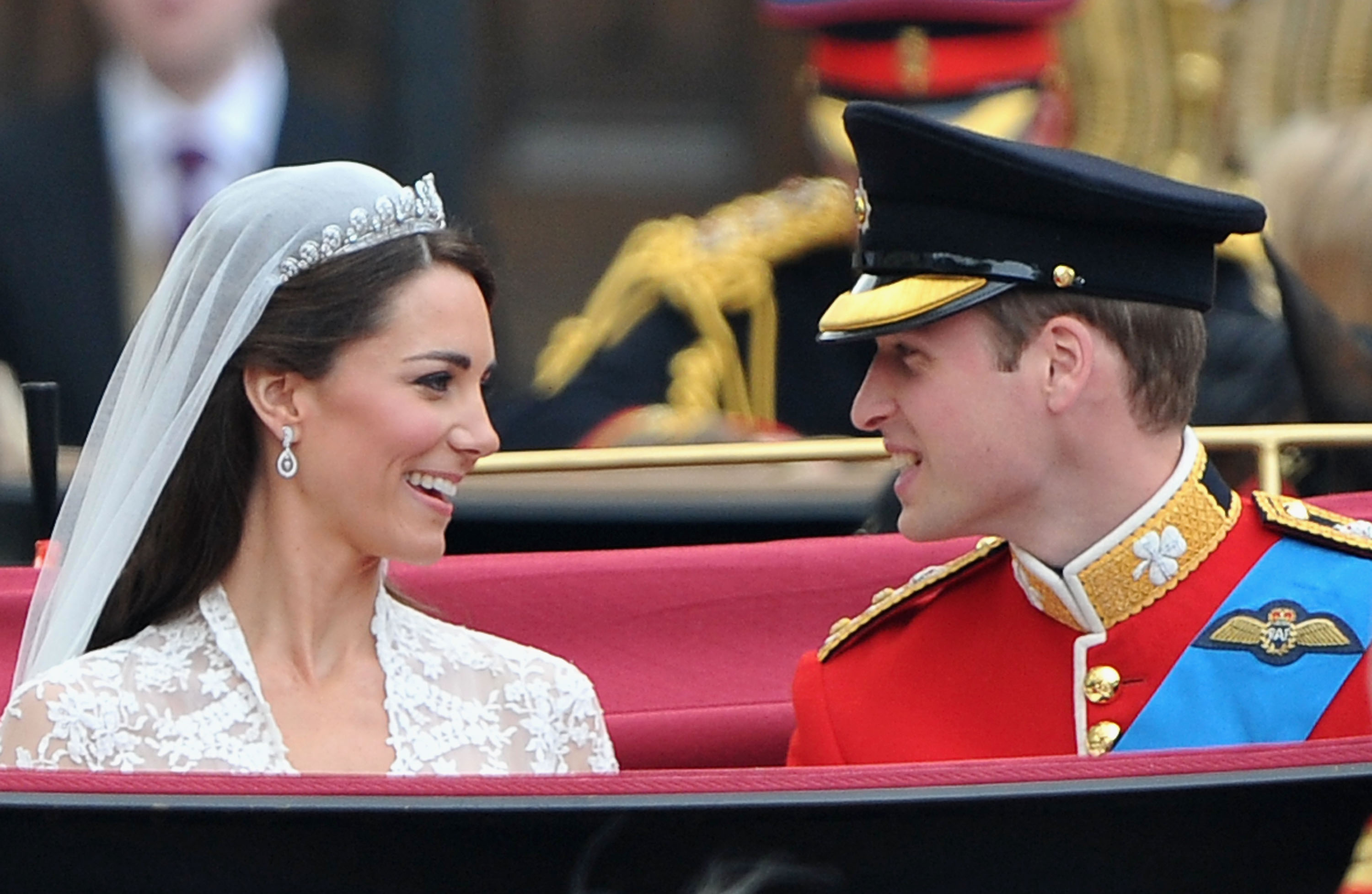 Kate Middleton and Prince William smile at eachother during carriage procession to Buckingham Palace following their wedding