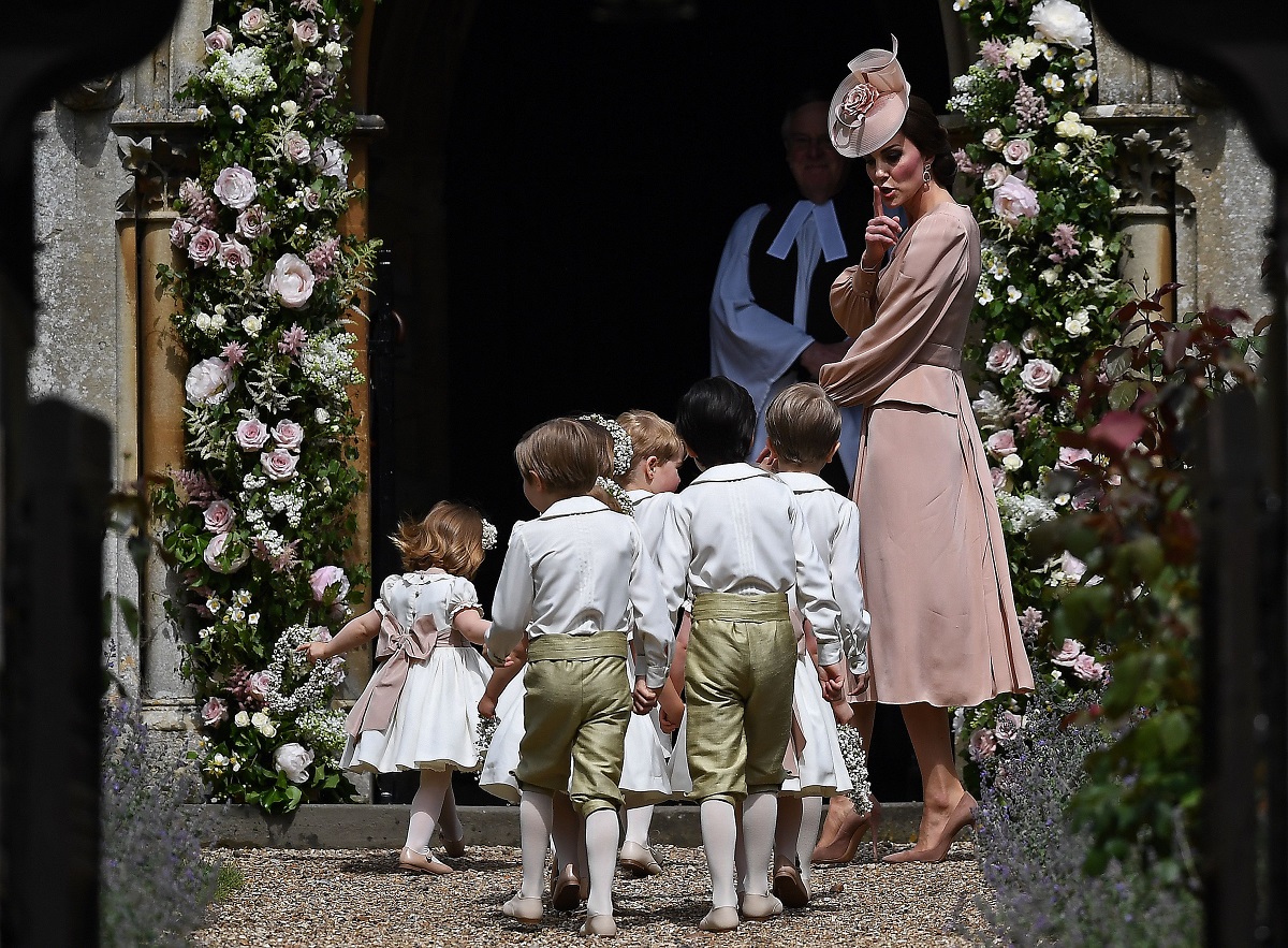 Kate Middleton gestures to the bridesmaids and pageboys as they arrive for Pippa Middleton's wedding to James Matthews