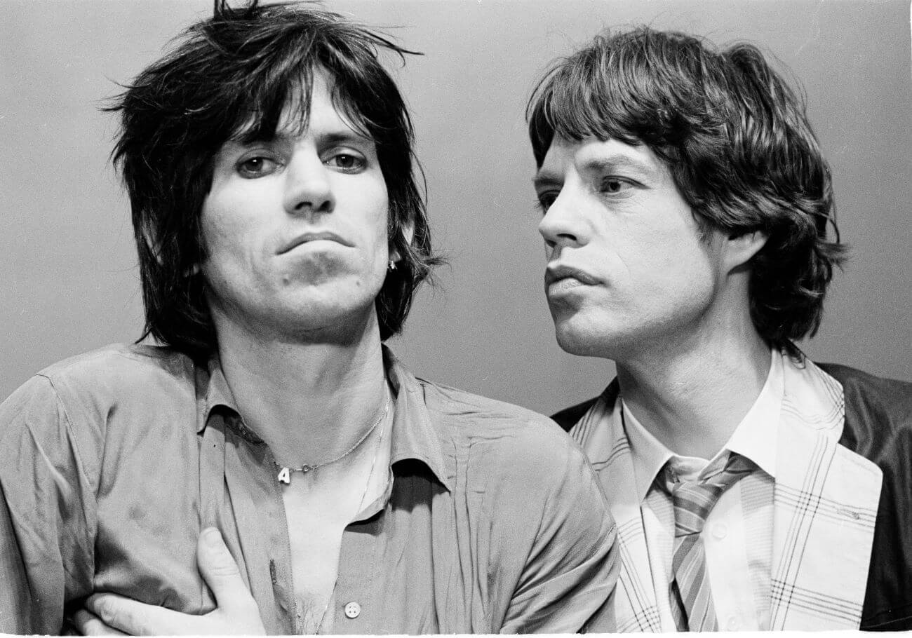 A black and white picture of Keith Richards staring at the camera and Mick Jagger staring at Richards.