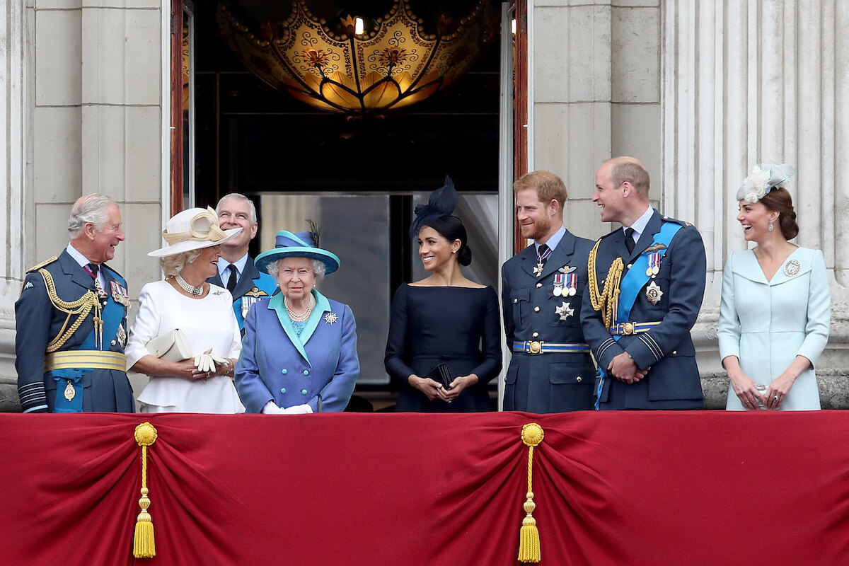 Meghan Markle, who isn't the 'driving force' behind royal family rift and exit, according to Robert Jobson's 'New King,' stands with Prince Harry and other British royals on the Buckingham Palace balcony