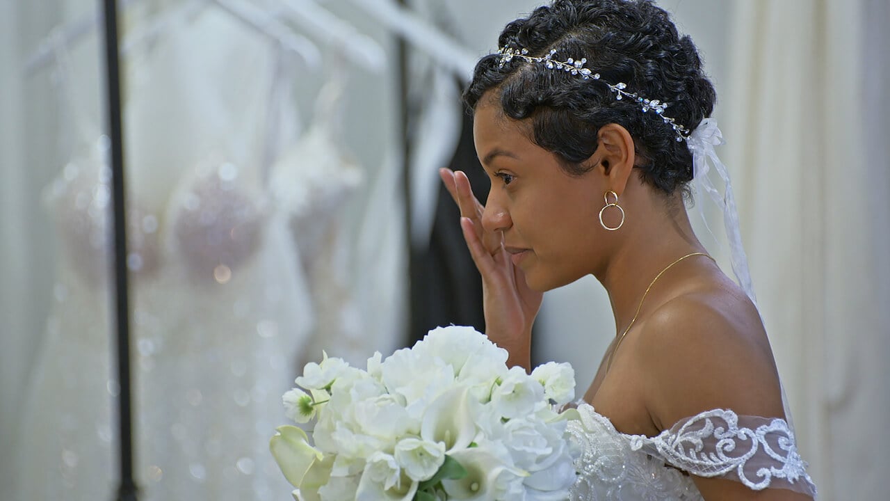 Iyanna McNeely on 'Love Is Blind' Season 2 wipes away a tear while wearing a wedding dress and holding white flowers.