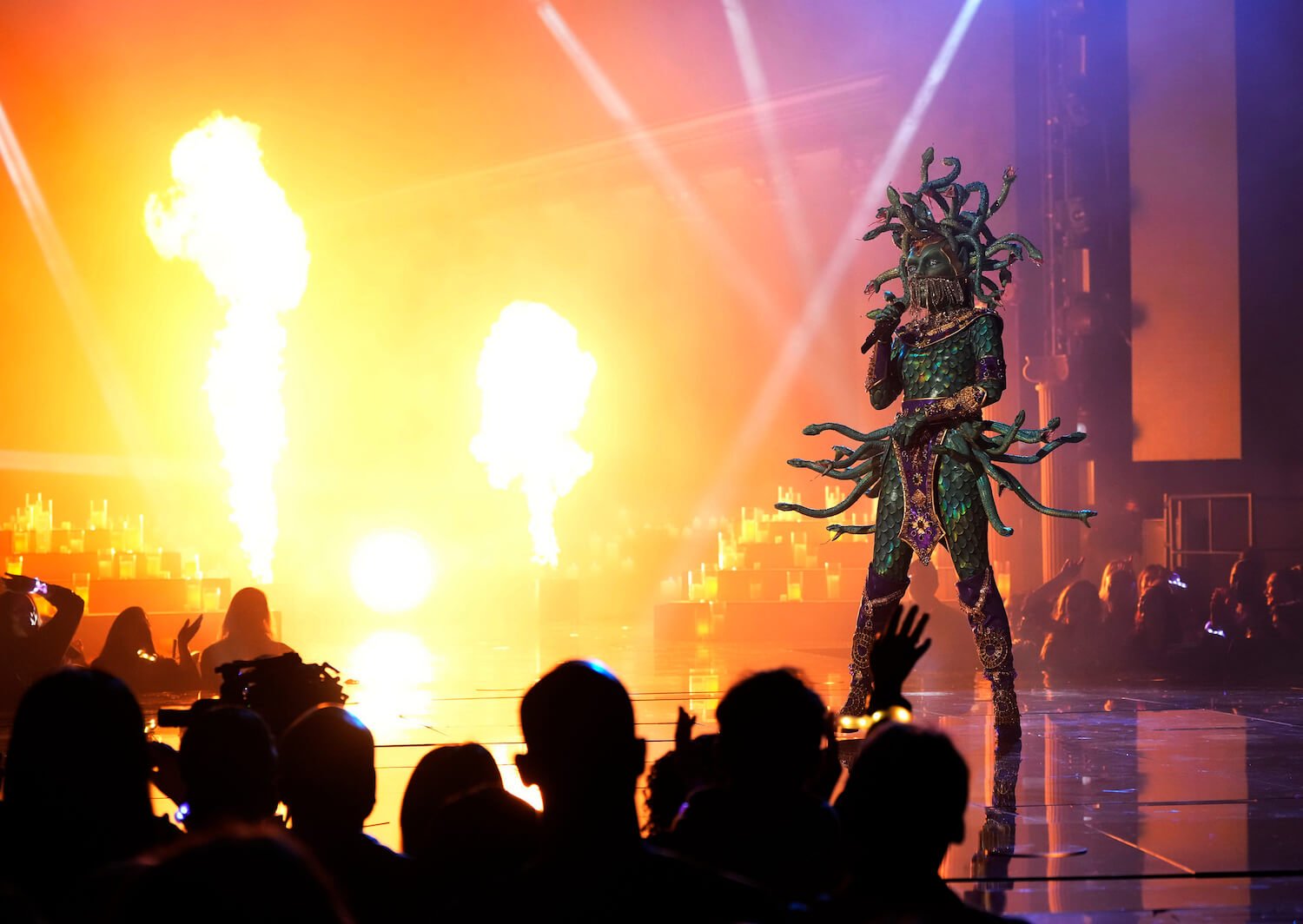 Medusa singing against a fire background in 'The Masked Singer' Season 9