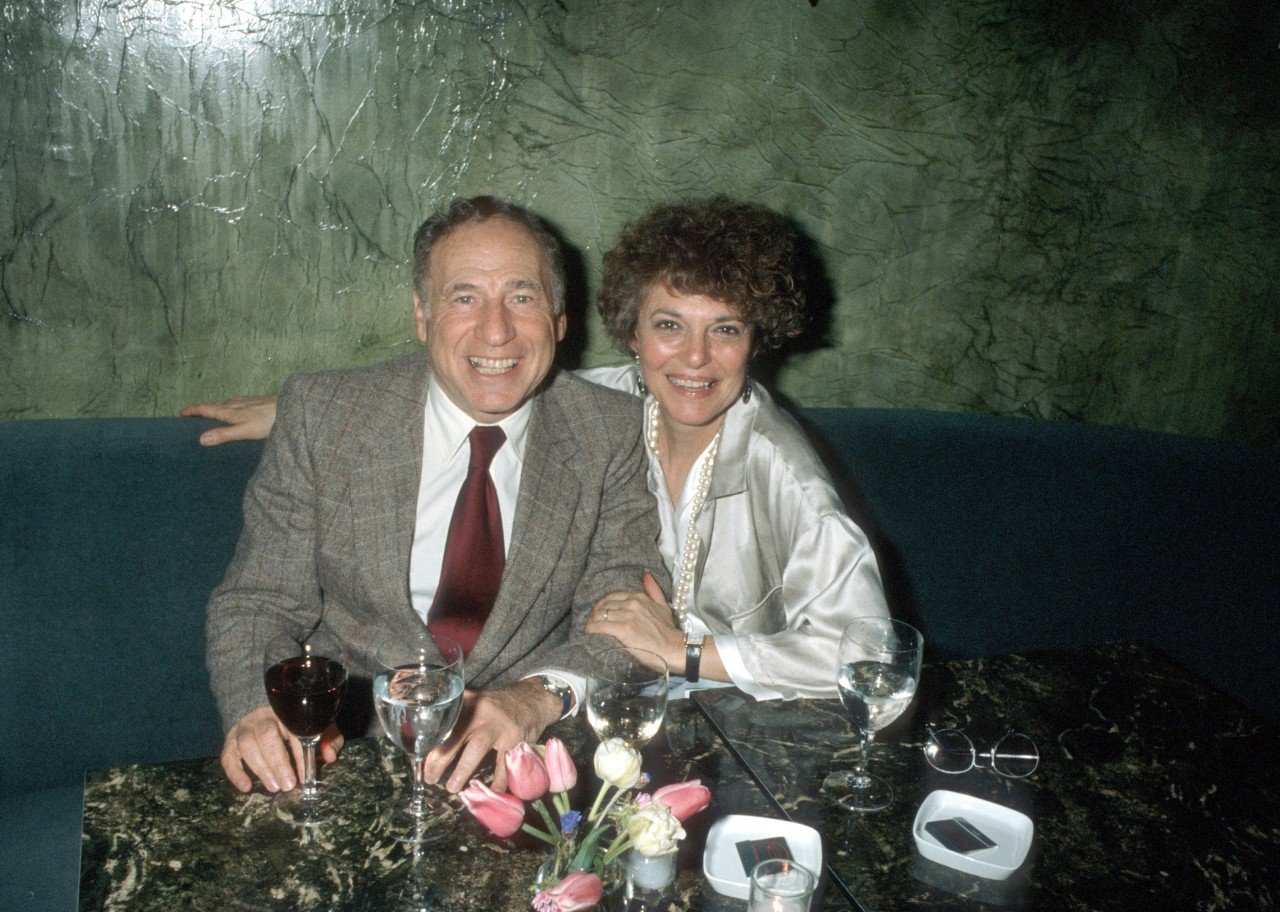 Mel Brooks and Anne Bancroft sit together.