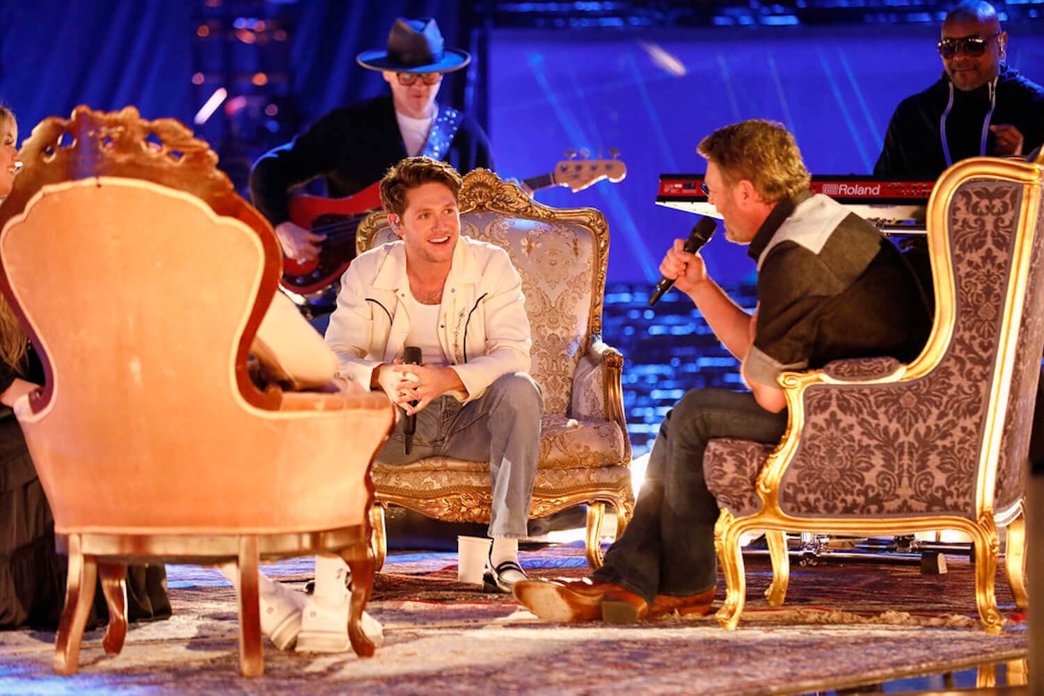 Niall Horan and Blake Shelton sitting across from each other in chairs in 'The Voice' Season 23