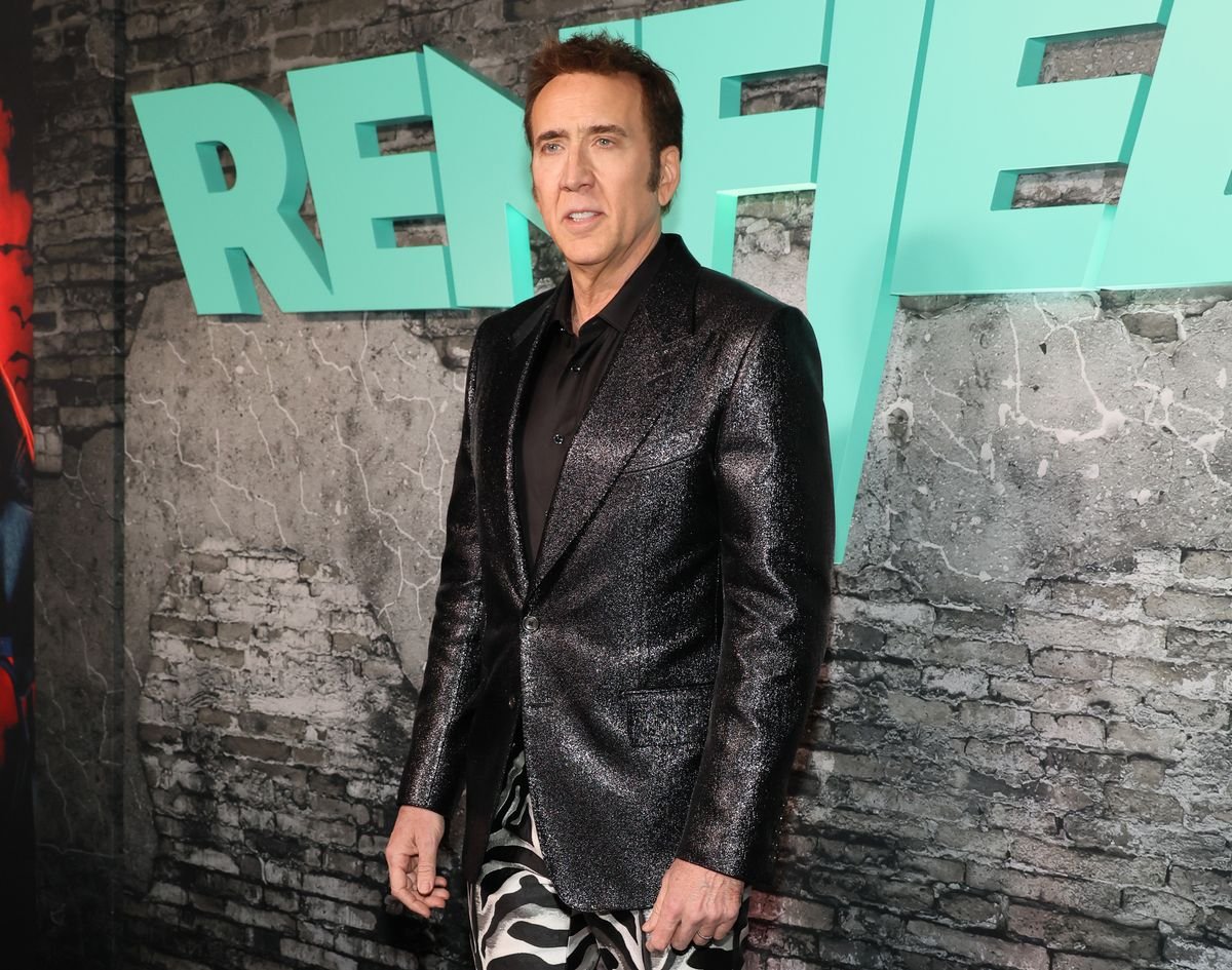 Nicolas Cage poses for a photo in front of a "Renfield" backdrop.