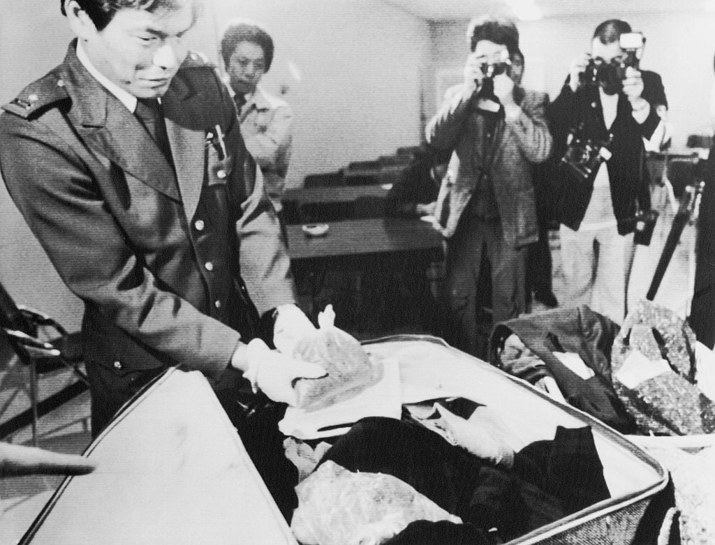 A customs officer goes through Paul McCartney's bag to uncover hidden marijuana.